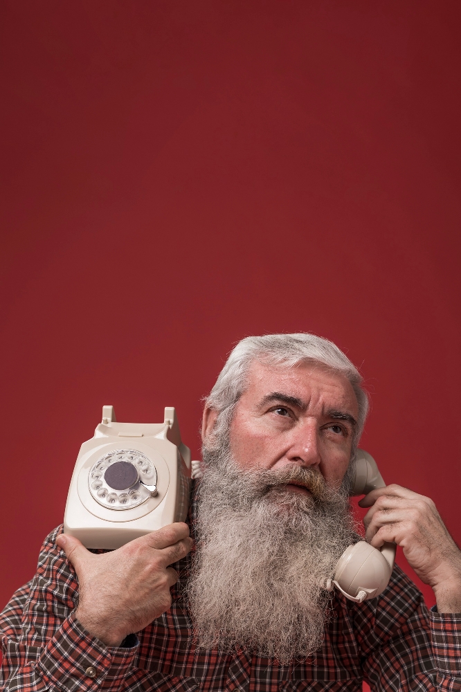 Close-up of an elderly man's hand holding a mobile phone.